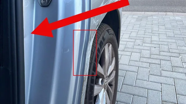 Rot markierte Verformung am Radlauf eines silbernen Fahrzeugs